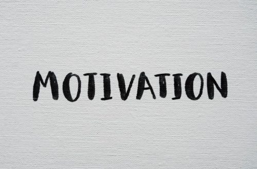 Inspirational word 'Motivation' in black on a white textured canvas background.